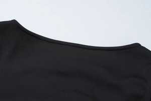 Close-up of the black knitted dress neckline showing high-quality stitching and fabric texture