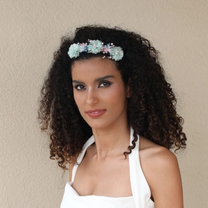 Close-up of model wearing floral headband with light blue and pink fabric flowers