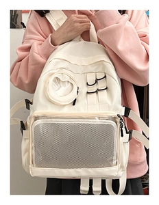 Close-up of minimalist white backpack with mesh pockets and stylish plastic buckles