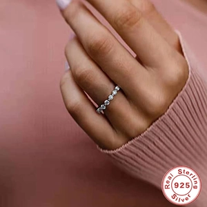 Close-up of sparkling 925 sterling silver diamond ring on hand with quality seal