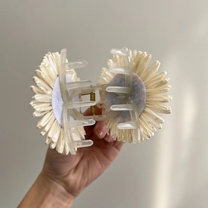 Detailed view of handmade raffia sunflower hair claw clip with transparent base