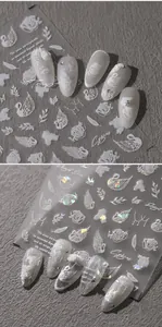 Detail of white embossed nail stickers with swan and rose patterns and elegant lettering