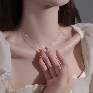 Elegant S925 silver bow necklace with tassel pendant on model for high-end fashion jewelry