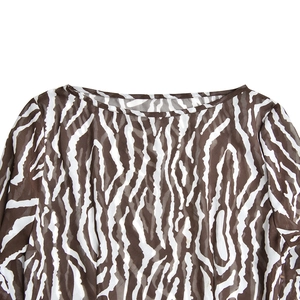 Close-up of crew neckline on a bohemian dress with brown zebra print pattern