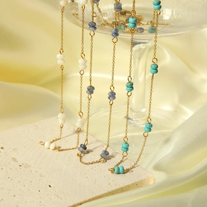 Detail of stacked stainless steel necklaces with colorful natural stone beads on a base