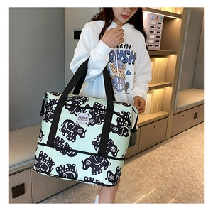 Detail view of large green travel bag with elephant print and durable nylon handles