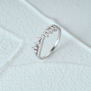 Macro shot of sparkling silver crown ring featuring round cubic zirconia on textured background