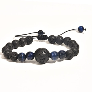Detail of adjustable woven lava stone bracelet with blue accent beads on white background