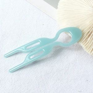 Detail view of the mint blue U-shaped acetate hair pin showing its smooth texture