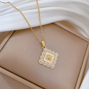Close-up of golden square cross pendant with pearls and crystals on silk background