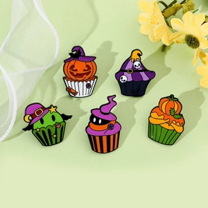 Detail of Halloween cupcake enamel pins with pumpkin, witch hat and skull designs