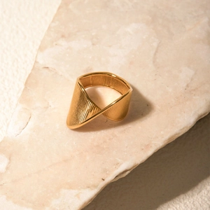 Macro detail of 18k gold twisted stainless steel ring with unique textured design