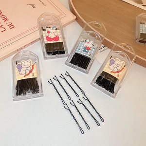 Close-up of black wave-shaped hair clips and transparent storage box with cute stickers
