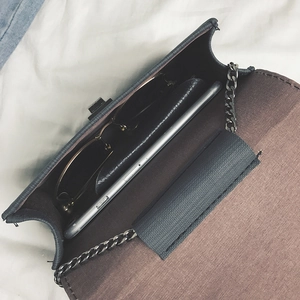 Minimalist chain crossbody bag showing capacity for phone and sunglasses