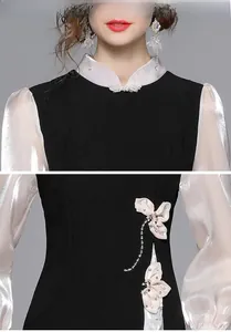 Dettaglio del colletto alla coreana e fiocco in vita con perle sull'abito Qipao