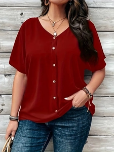 Detail of red V-neck short sleeve buttoned shirt with bohemian style jewelry and jeans
