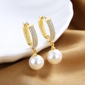 Elegante vergoldete Perlenohrringe mit Mikro-Pavé-Kristallen auf weißer Seide