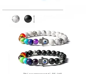 Détail de bracelets en howlite blanche et pierre noire mate de 8mm avec main de Fatma