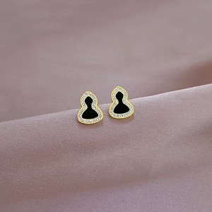 Macro shot of titanium steel wulu stud earring with gold finish and zircon inlay