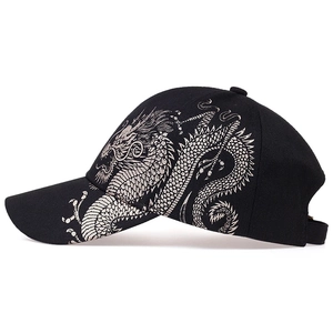 Detail of silver dragon embroidery on side of black cotton baseball cap with professional finish