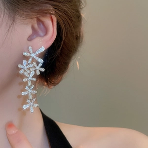 Detail of silver long floral tassel earrings with sparkling zircons worn by a model
