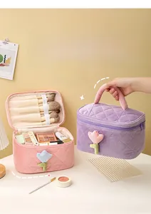 Detail view of corduroy makeup bag with quilted texture and tulip flower applique