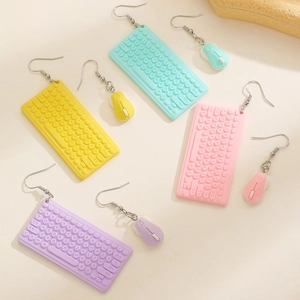 Close-up of colorful computer mouse and keyboard earrings in macaron resin tones
