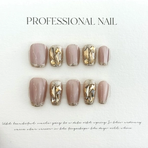 Vue détaillée de faux ongles mats roses avec pointes dorées pailletées et strass