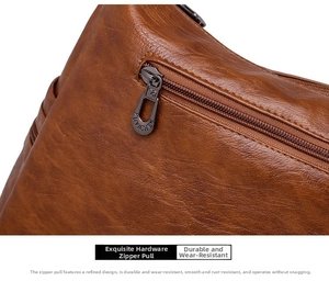 Close-up of durable dark grey metal zipper pull on textured brown faux leather bag