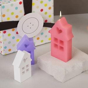 Détails des motifs de cœur évidés sur des bougies parfumées en forme de maison