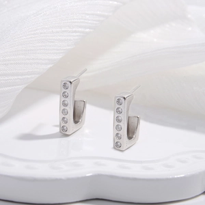Macro detail of S925 sterling silver J-shaped earrings with sparkling zircon inlay
