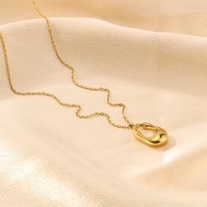 Minimalist 18K gold-plated geometric hollow oval pendant necklace on beige silk