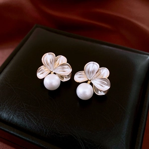 Close-up of vintage flower pearl earrings with 18K gold plating and white enamel petals