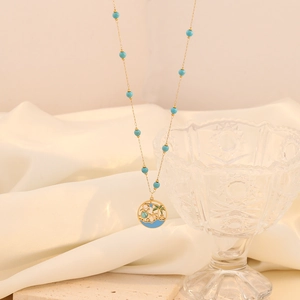 Gold-tone layered necklace with turquoise beads and palm tree beach pendant
