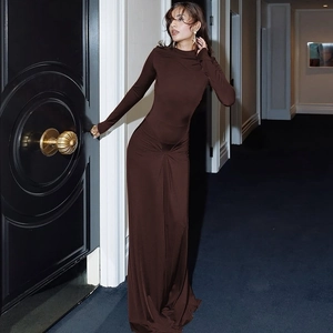 Detail of the slim fit long sleeve brown knit dress with an elegant floor-length hemline
