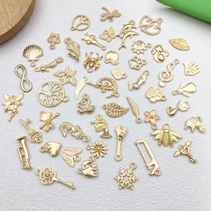 Flat lay of assorted gold-plated charms including music notes, animals, and nature symbols