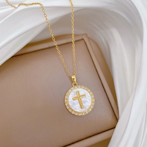 Close-up of luxury gold-plated cross pendant necklace with pavé diamonds on silk background
