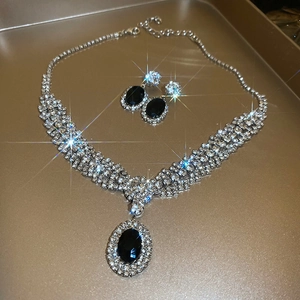 Macro shot of silver zircon jewelry set featuring black oval crystals and rhinestones