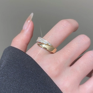 Detail of gold-plated crossover ring featuring micro-pave cubic zirconia on model finger