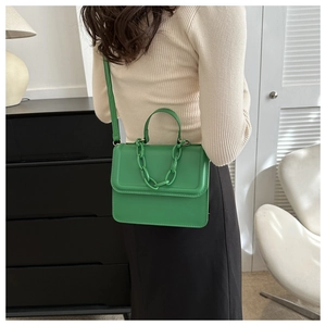 Green PU leather crossbody bag with chunky chain detail shown on a model
