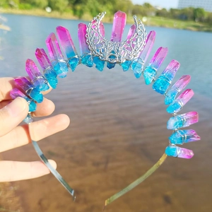 Macro detail of blue-pink crystal crown with hollow moon ornament held over water