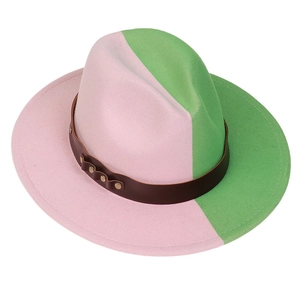 Detail of two-tone pink and green fedora hat with brown leather band and metallic studs