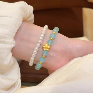 Primer plano de pulseras de cuentas de piedra natural azul y perlas blancas