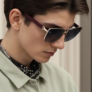 Detail of luxury polarized sunglasses with gold metal frame and decorative C-hinge