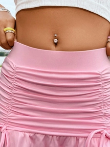Primer plano de un piercing de ombligo plateado con circonita clara en el modelo