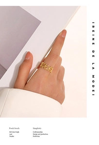 Détail d'une bague chaîne à maillons cœur dorée 18 carats portée dans un style épuré