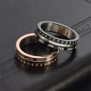 Rotating stainless steel calendar ring set in rose gold and black with engraved dates
