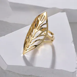 Macro detail of adjustable gold leaf ring with hollow vein pattern on white stone