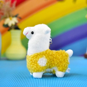 Side view of a cute white and yellow alpaca plush keychain with soft fluffy texture