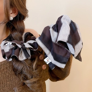 Macro shot of striped fabric hair scrunchie with detailed soft texture and small woven label